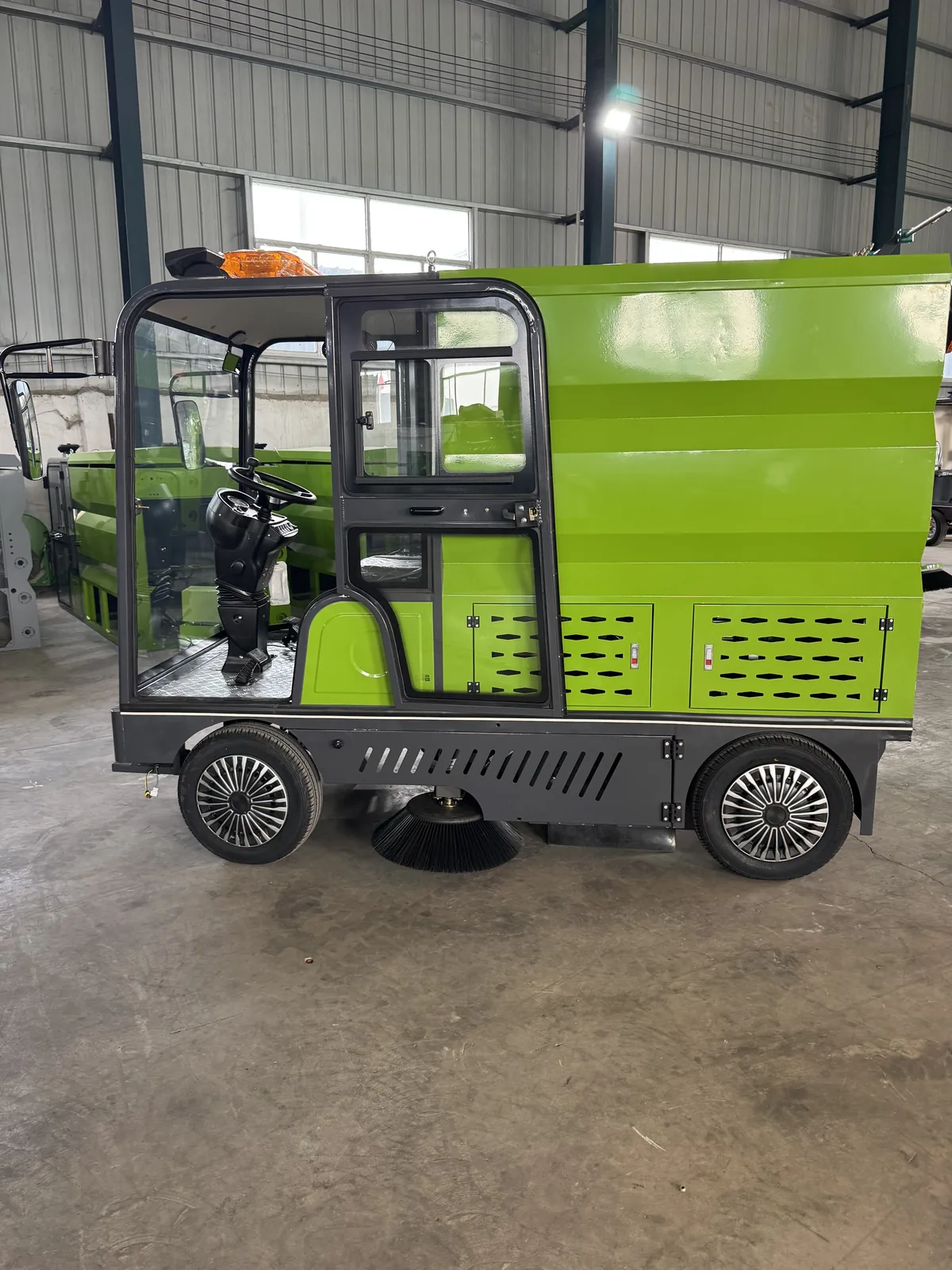 Side view of a compact sanitation sweeper